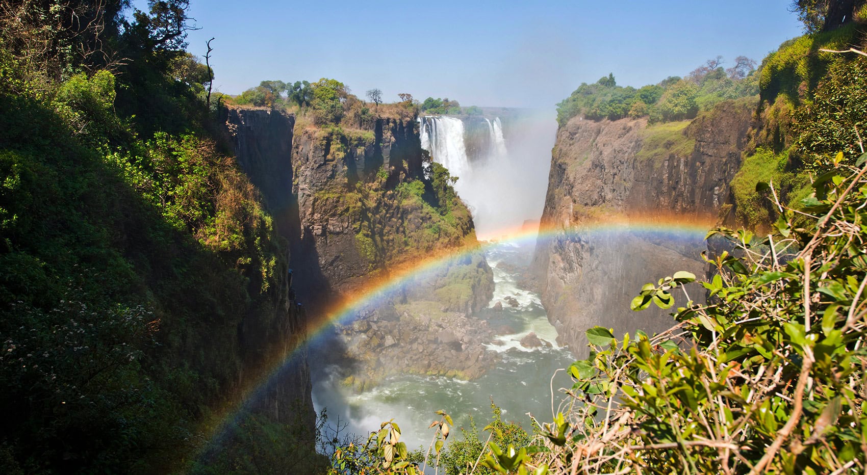 Ein Regenbogen vor den Wasserfällen der Viktoriafälle