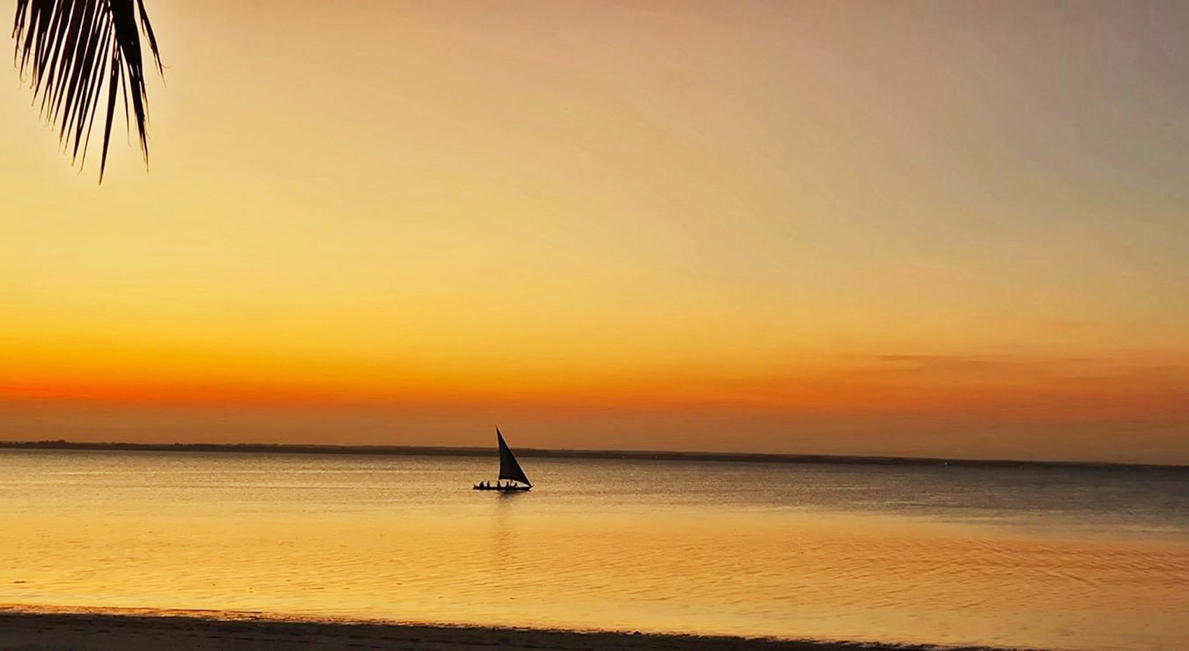 Ein Dhow Segelboot bei Sonnenuntergang auf Sansibar.
