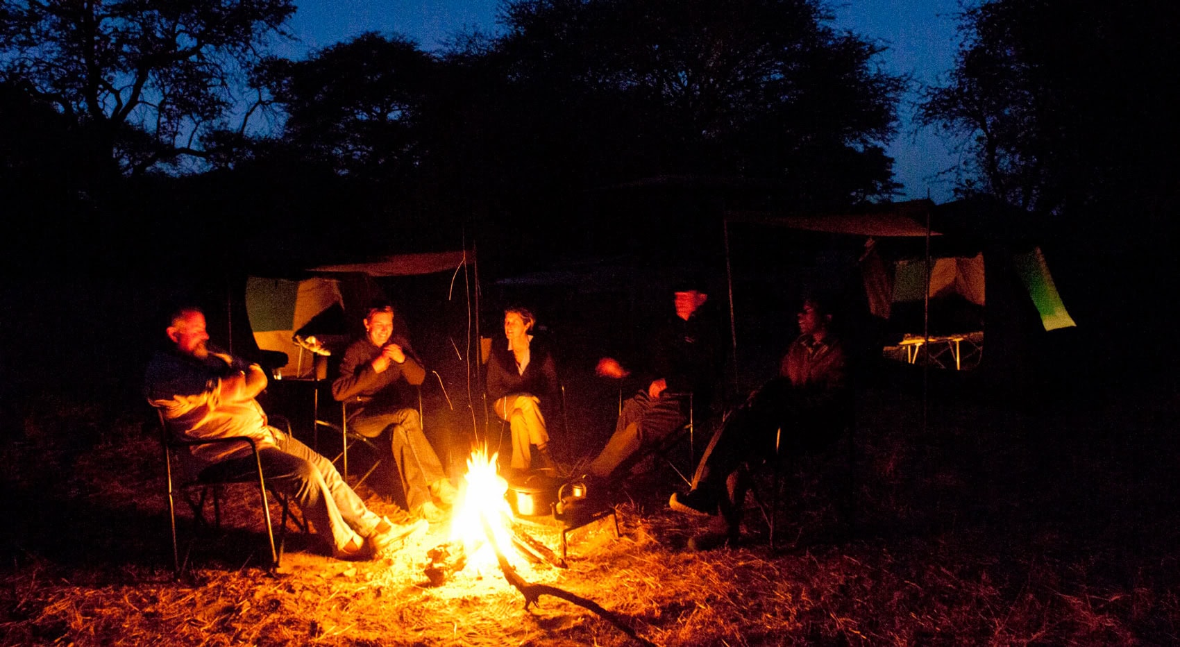 Gäste an einem Lagerfeuer in Botswana. Gäste an einem Lagerfeuer in Botswana.