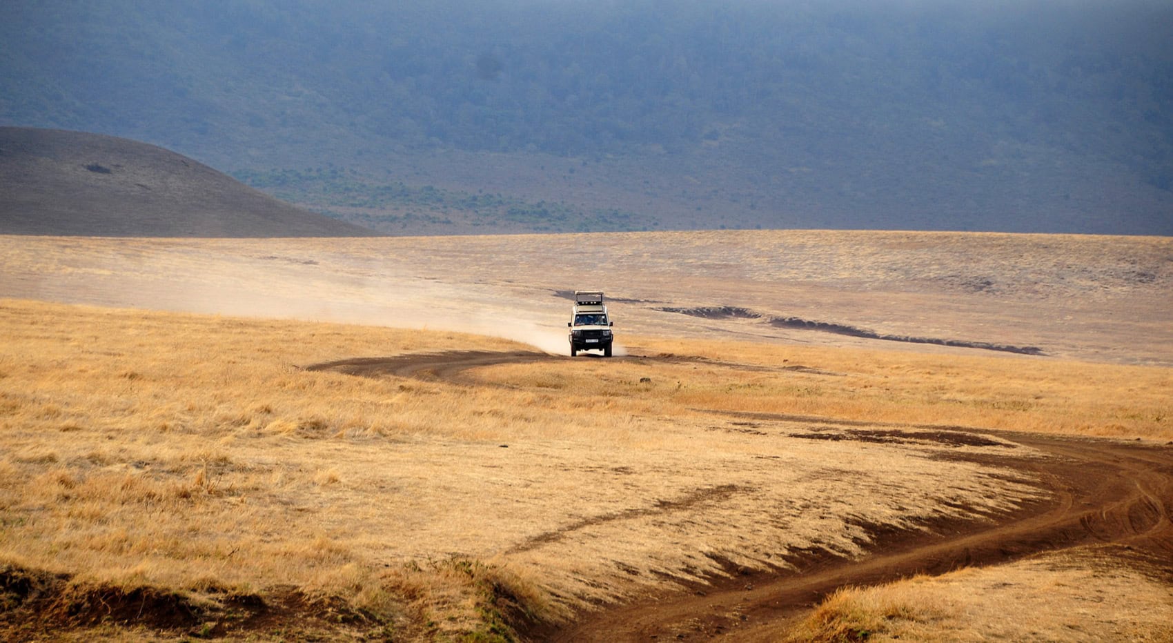 Ein Fahrzeug fährt durch den Ngorongoro Krater in Tansania.