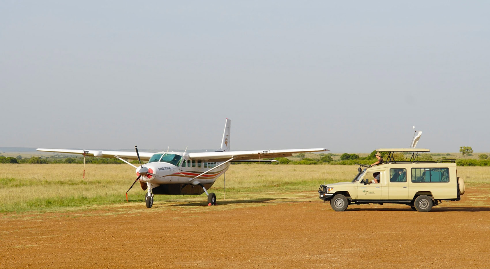 Ein Safarifahrzeug neben einem Kleinflugzeug in der Masai Mara. Ein Safarifahrzeug neben einem Kleinflugzeug in der Masai Mara.