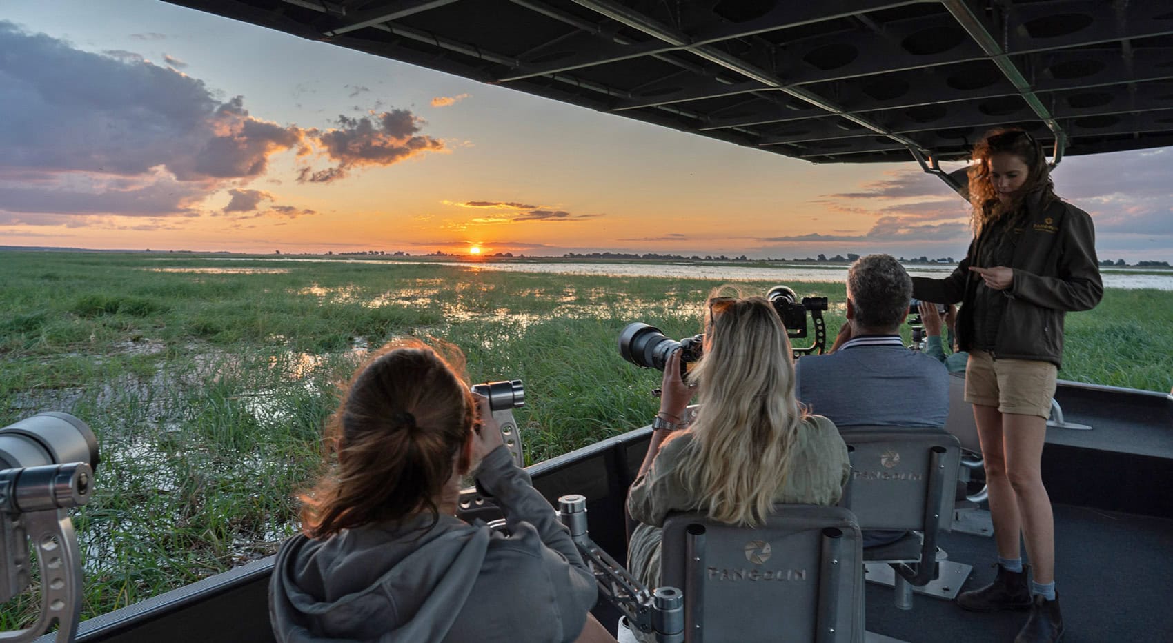 Bootsafaris im Chobe Nationalpark sind ein Highlight einer jeden Botswana Reise, Diese Gäste fotografieren den Sonnenuntergang vom Boot aus. Bootsafaris im Chobe Nationalpark sind ein Highlight einer jeden Botswana Reise, Diese Gäste fotografieren den Sonnenuntergang vom Boot aus.