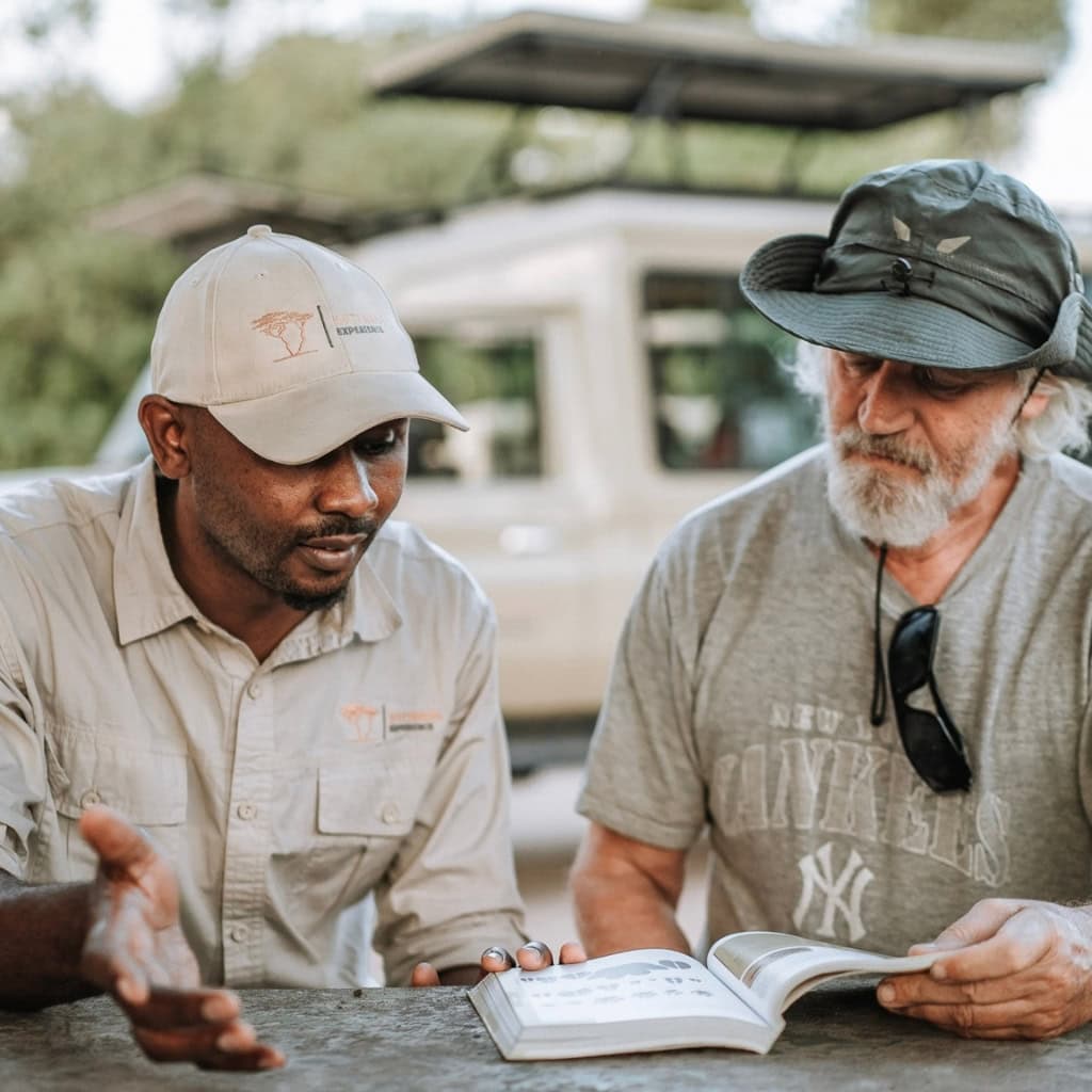 Safariguide und Gast studieren Handbuch
