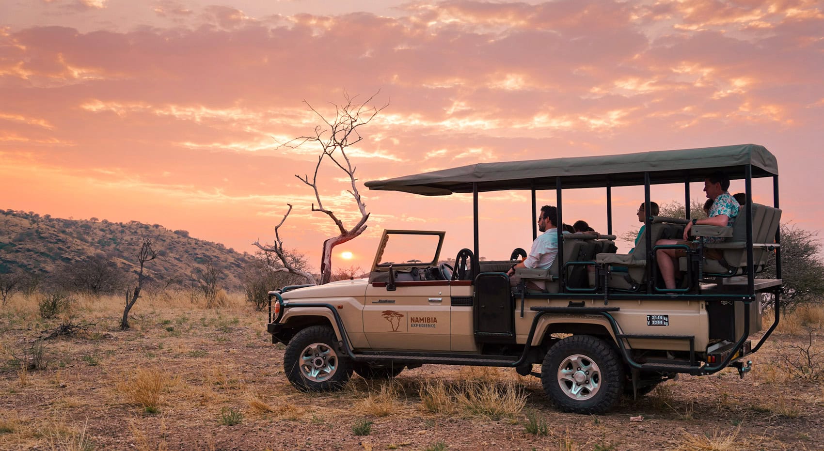 Ein offenes Safariauto mit Gästen im Etosha Nationalpark. Ein offenes Safariauto mit Gästen im Etosha Nationalpark.