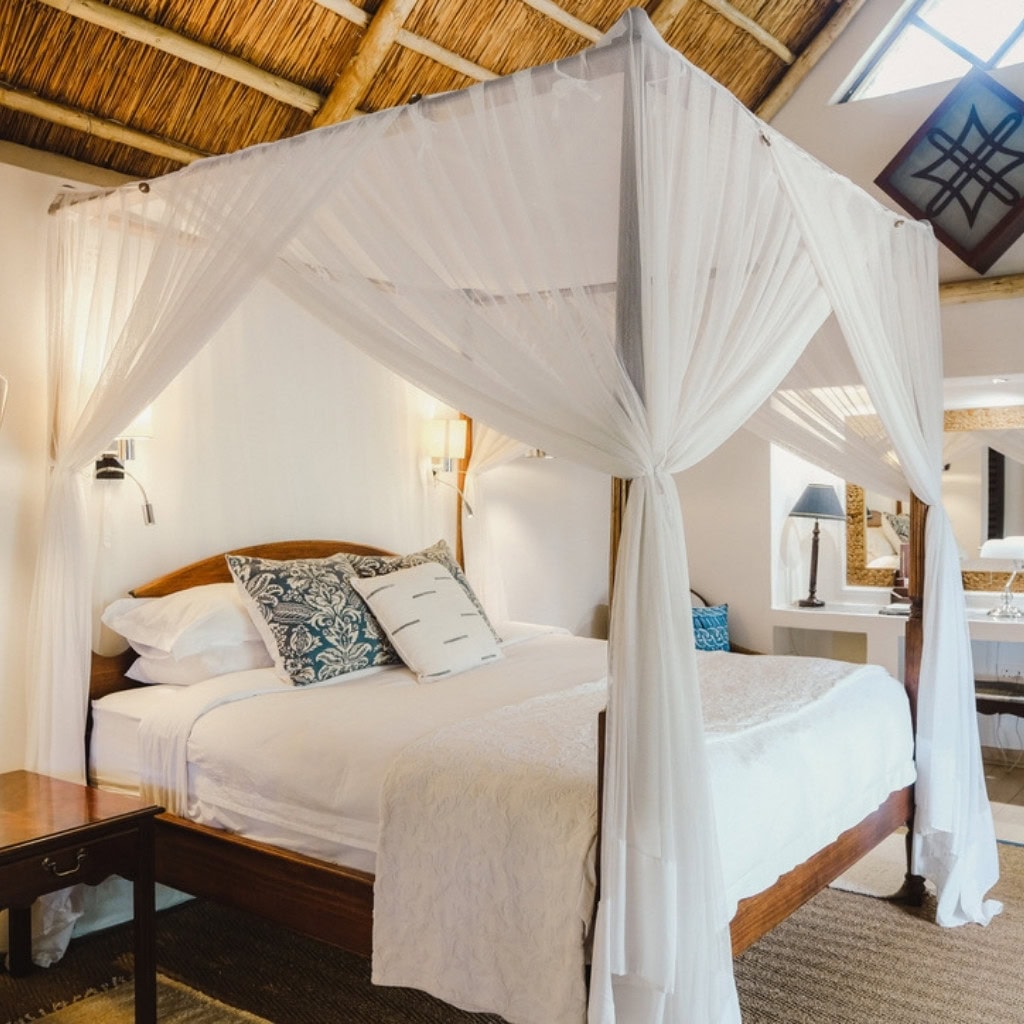 Himmelbett mit Ausblick auf Savanne in der Amanzi Lodge