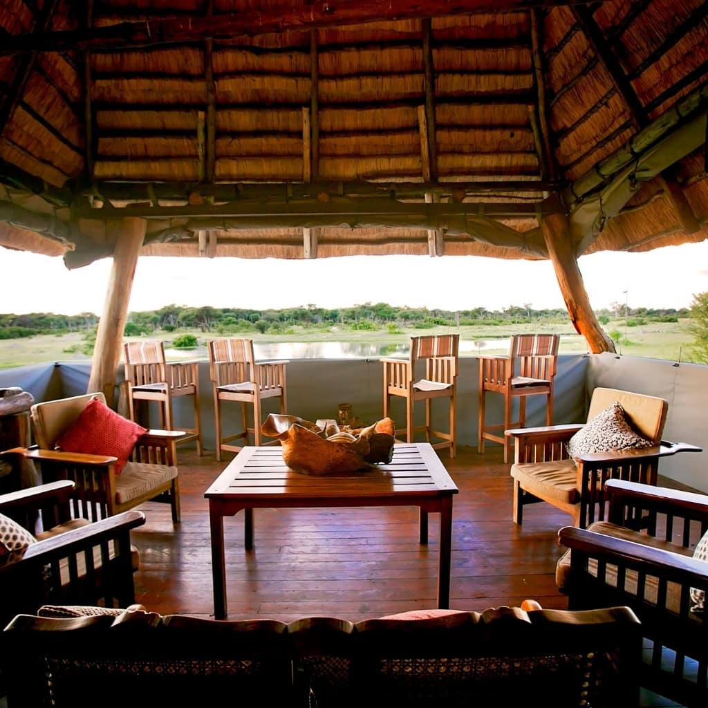 Terrasse mit Blick auf das Wasserloch der The Hide Camp Lodge Simbabwe.