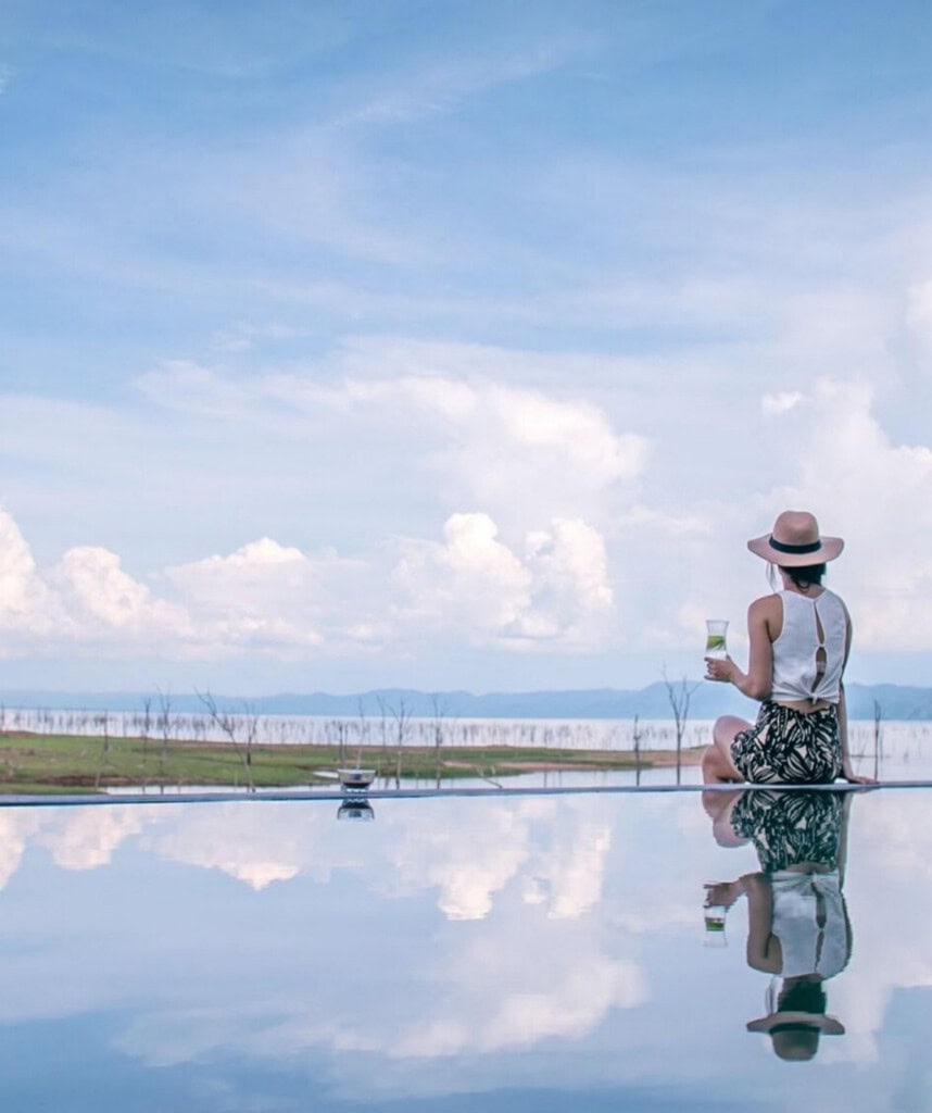 Gast sitzt am Changa Camp Infinity Pool mit blick auf Lake Kariba