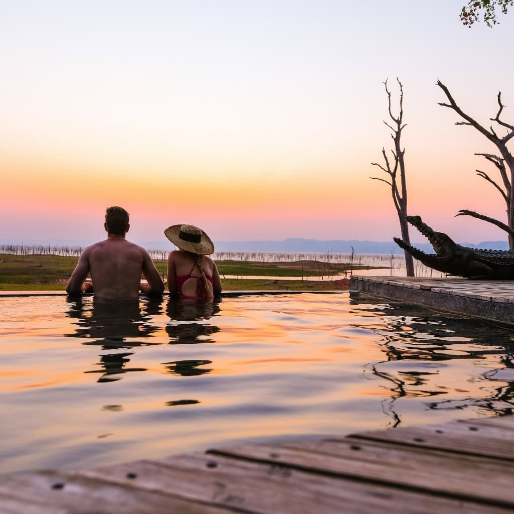 Gäste im Infinity Pool mit Blick auf den Lake Kariba Simbabwe.