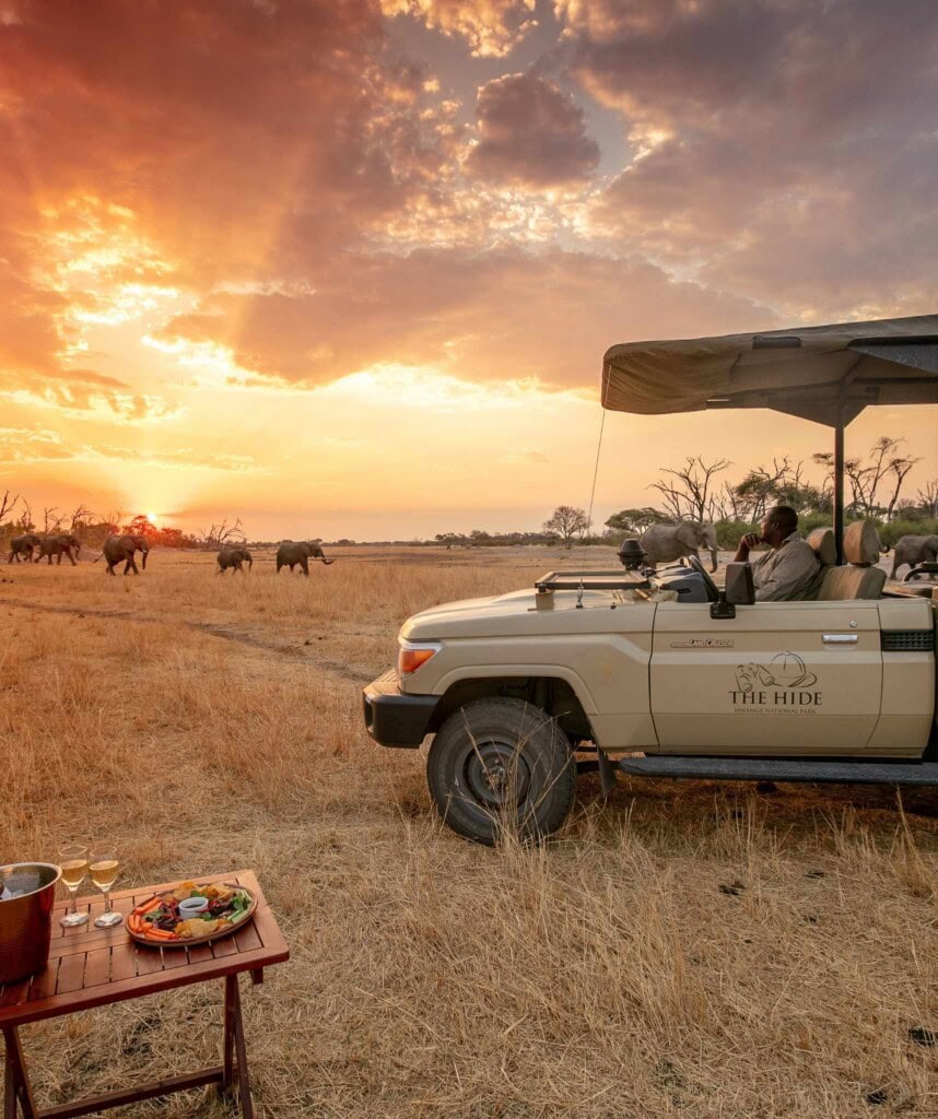 Safari Fahrzeug mit Elefanten und dramatischem Himmel The Hide Lodge
