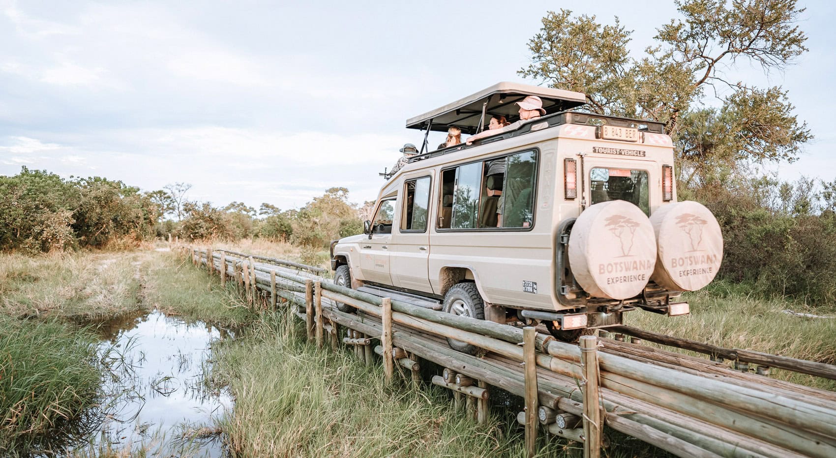 Ein Safarifahrzeug fährt über eine Brücke im Moremi Game Reserve.